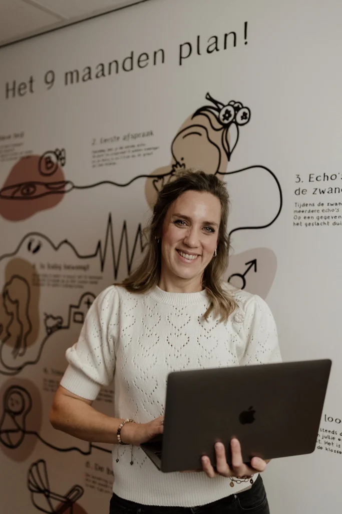 Medewerker van Verloskundige Ochten die een laptop vasthoudt voor het 9 maanden plan